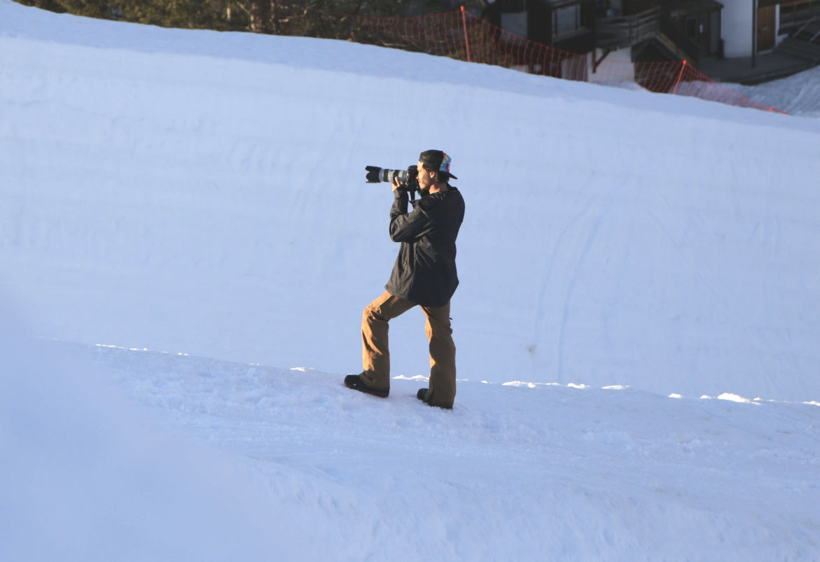 man in snow using a camera