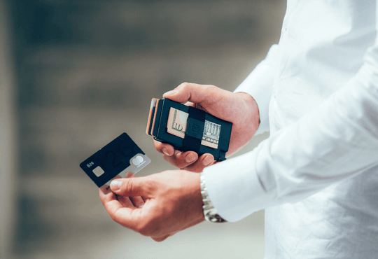 man removing card from slim leather wallet