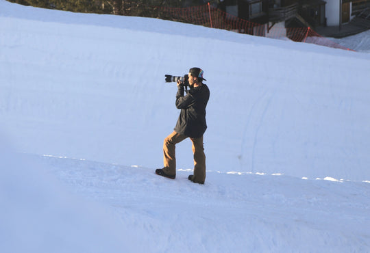 man in snow using a camera