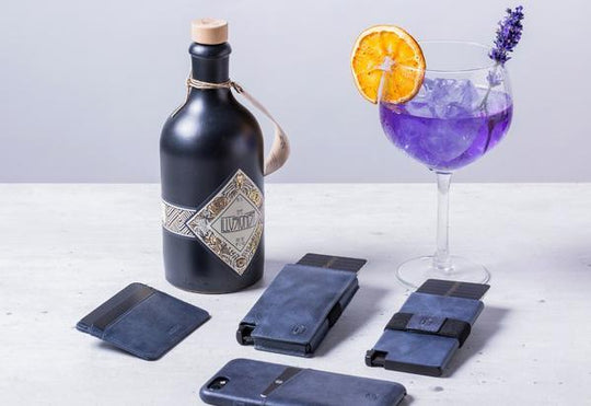 blue leather wallets sitting next to bottle of gin