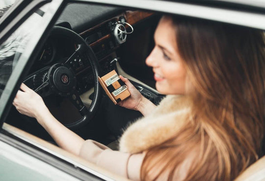 woman in car holding slim leather wallet