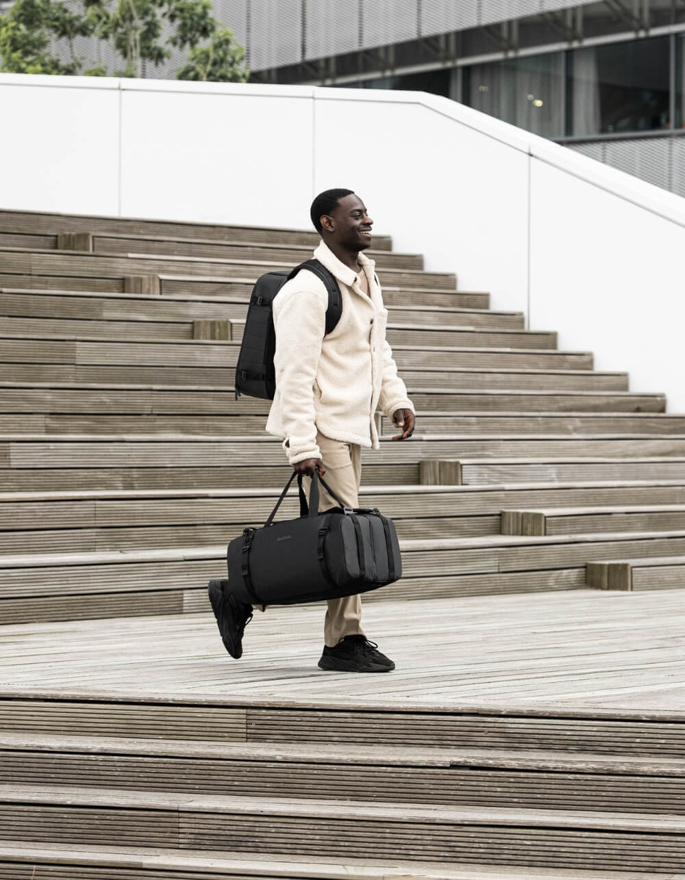 Man walking to airport with best backpack and duffel bag for carry-on travel