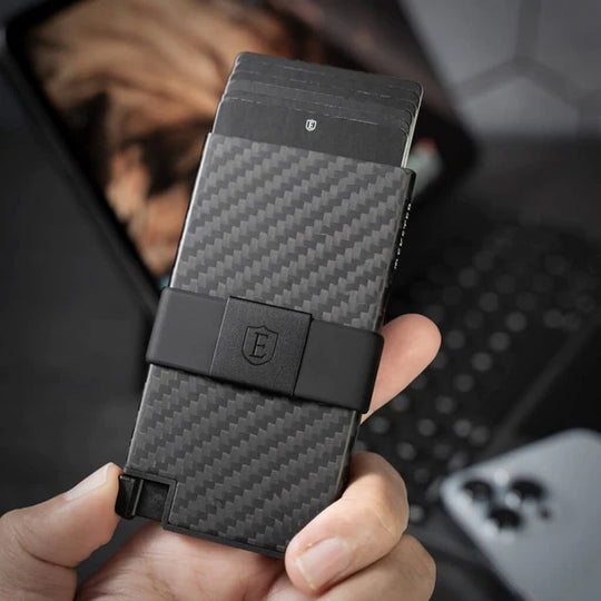 Carbon Cardholder held in hand whilst clicking the quick card access button
