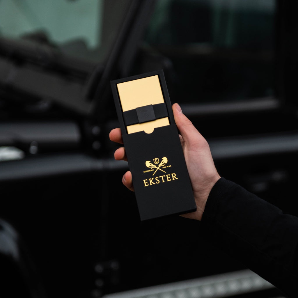 18K Gold Aluminum Cardholder shown inside of it black packaging