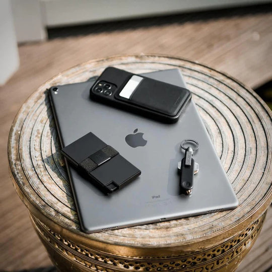 Keyholder with LED light shown on table with iPad, iPhone and aluminum cardholder